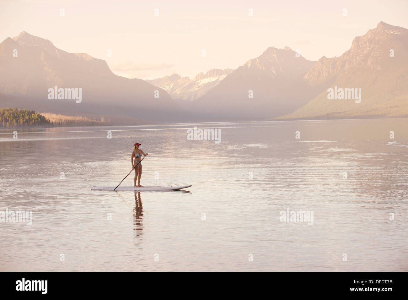 Mujer en canoa, el lago McDonald, el parque nacional de Glacier, Montana, EE.UU. Foto de stock