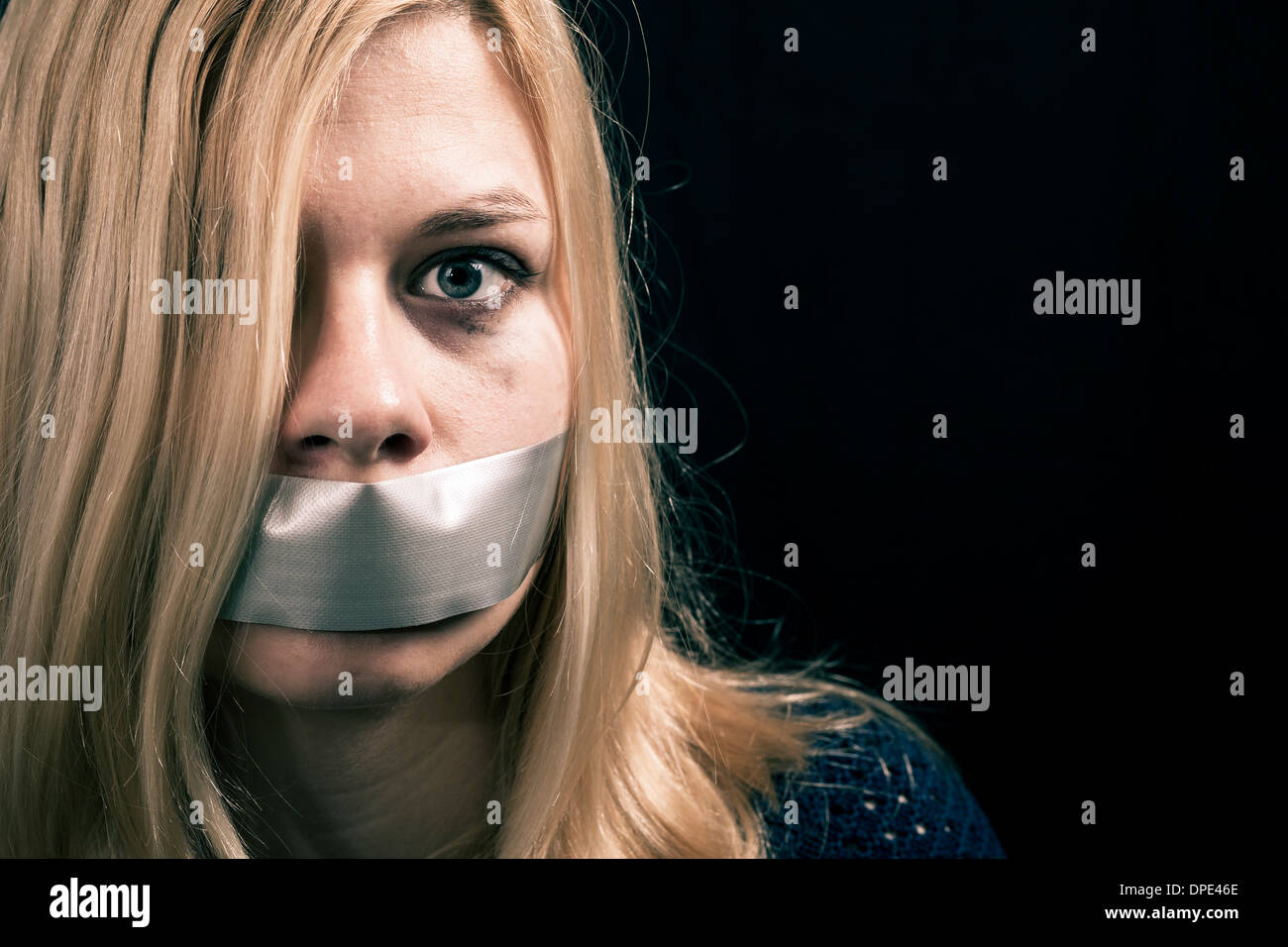 Retrato de mujer asustada secuestrados como rehenes con cinta adhesiva sobre su boca Foto de stock