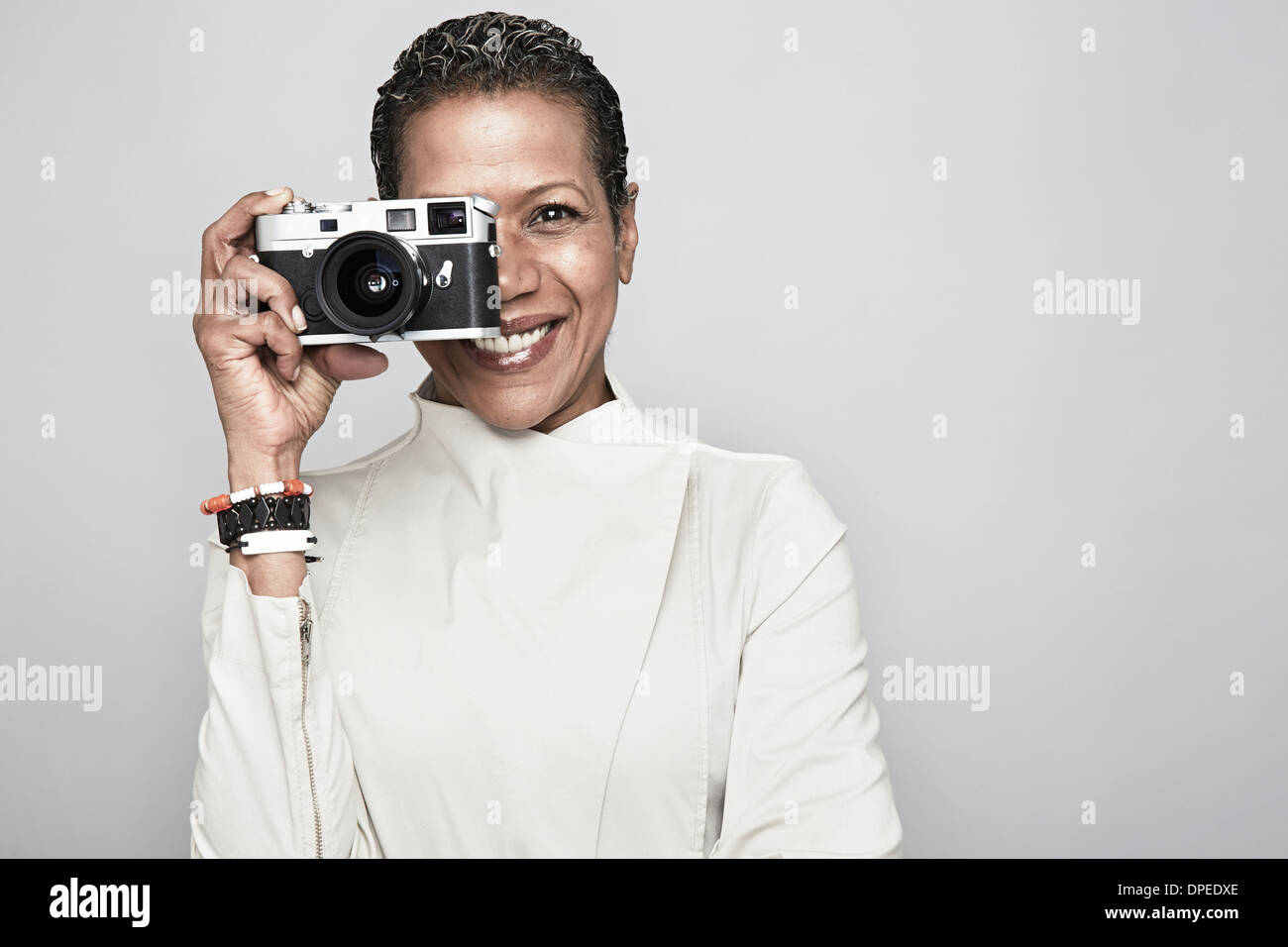 Retrato de estudio de feliz mujer madura, sosteniendo la cámara Fotografía  de stock - Alamy