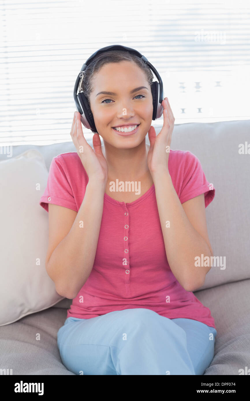 Calmful mujer escuchando música en el sofá Foto de stock