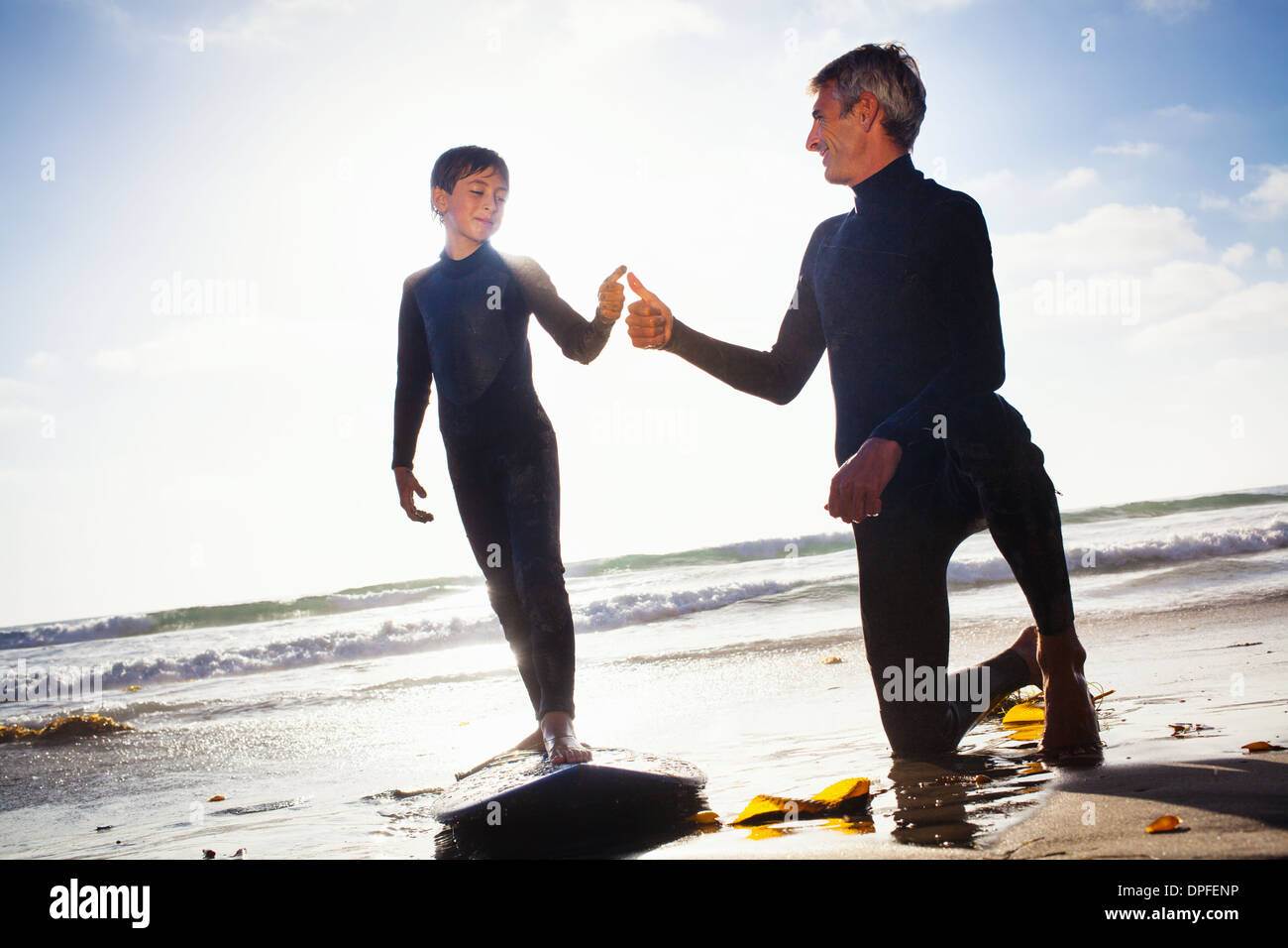 Padre e hijo con tablas de surf en la playa, Encinitas, California, EE.UU. Foto de stock