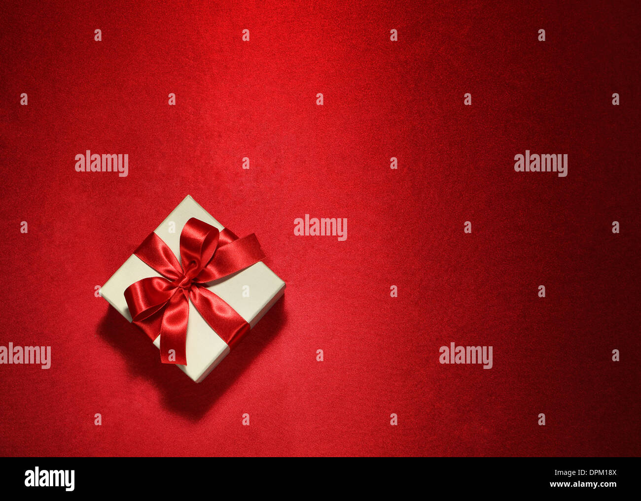 Caja de regalo blanco sobre fondo rojo. Foto de stock