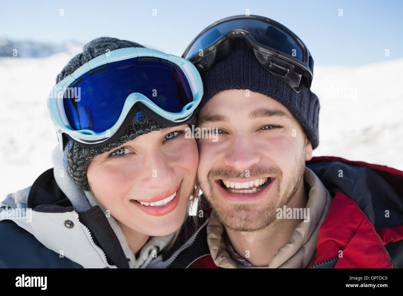 Cerca de una encantadora pareja con gafas de esquí en la nieve Foto de stock