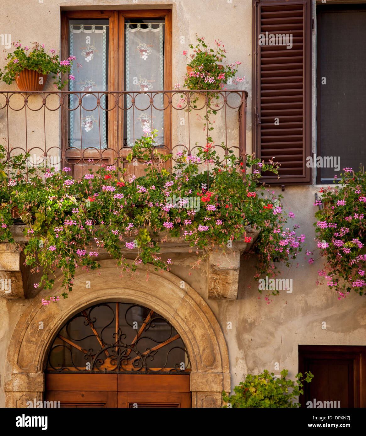 Flores en el balcón de su casa en la puerta delantera Piezna, Toscana, Italia Foto de stock