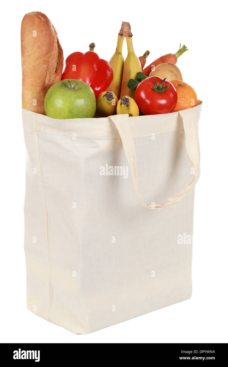Bolso de compras lleno reutilizable con un pan, verduras y frutas, aislado en blanco Foto de stock