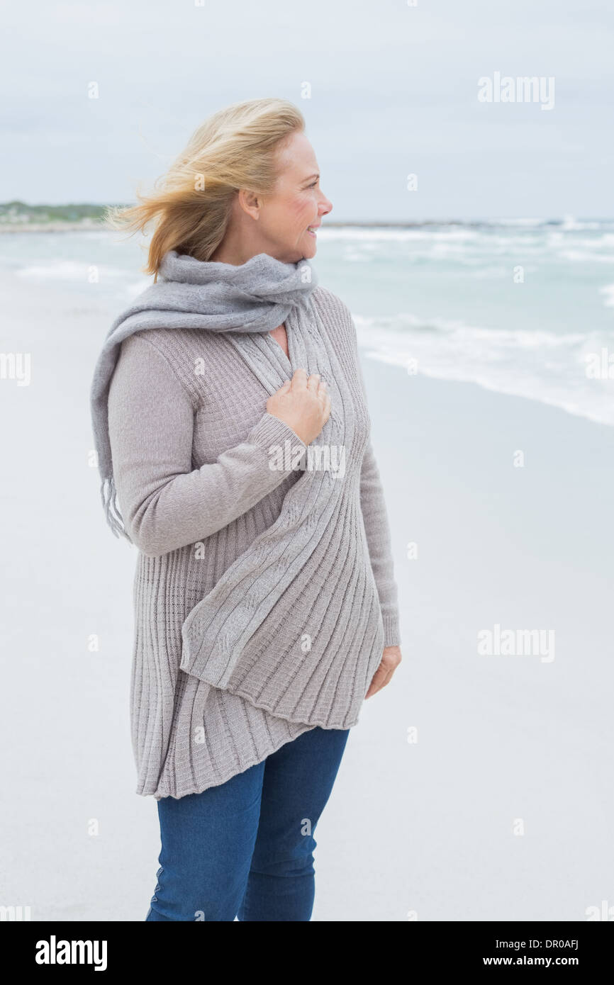 Mujer senior casual contemplativa en la playa Foto de stock