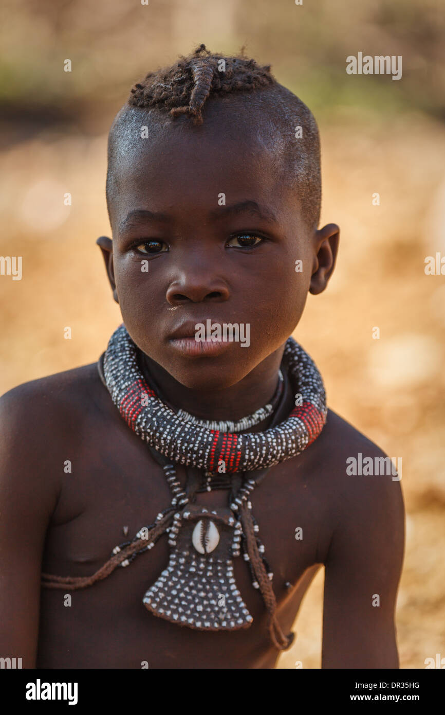Retrato de niño usando Himba fancy collares tribales y peinado en Damaraland, Namibia, África Foto de stock