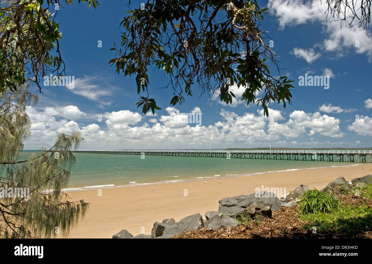 El paisaje costero en Hervey Bay, Queensland, Australia , con Urangan histórico muelle, playa y océano turquesa bajo un cielo azul Foto de stock