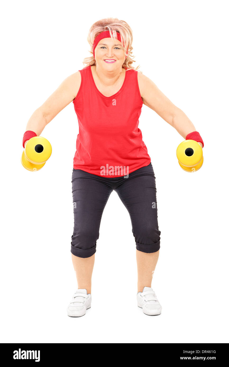Longitud total retrato de mujer de mediana edad hacer ejercicio con pesas Foto de stock