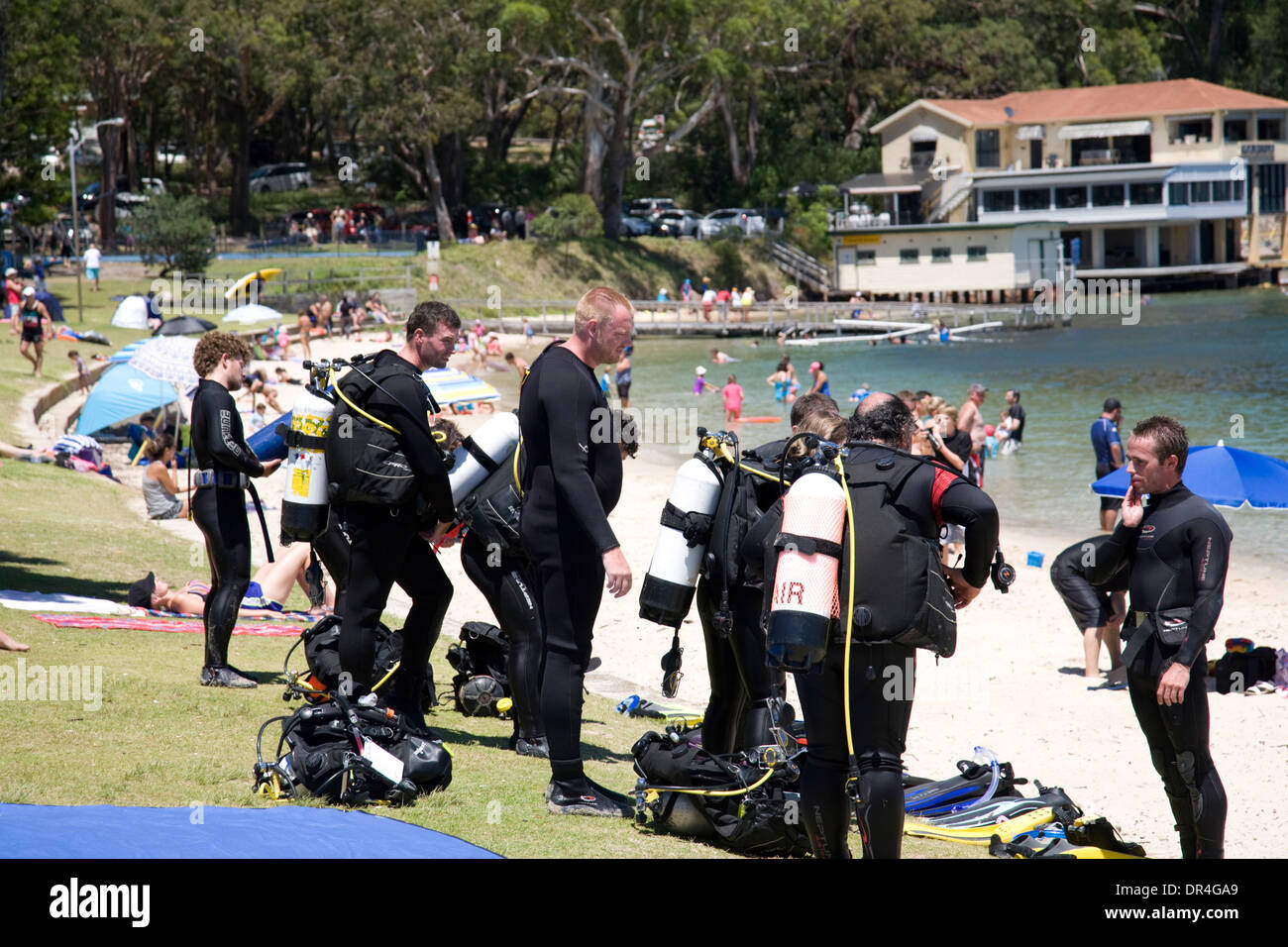 Los buceadores se prepara para entrar en el océano por la pequeña playa en la Bahía Nelson,Port Stephens, Australia Foto de stock