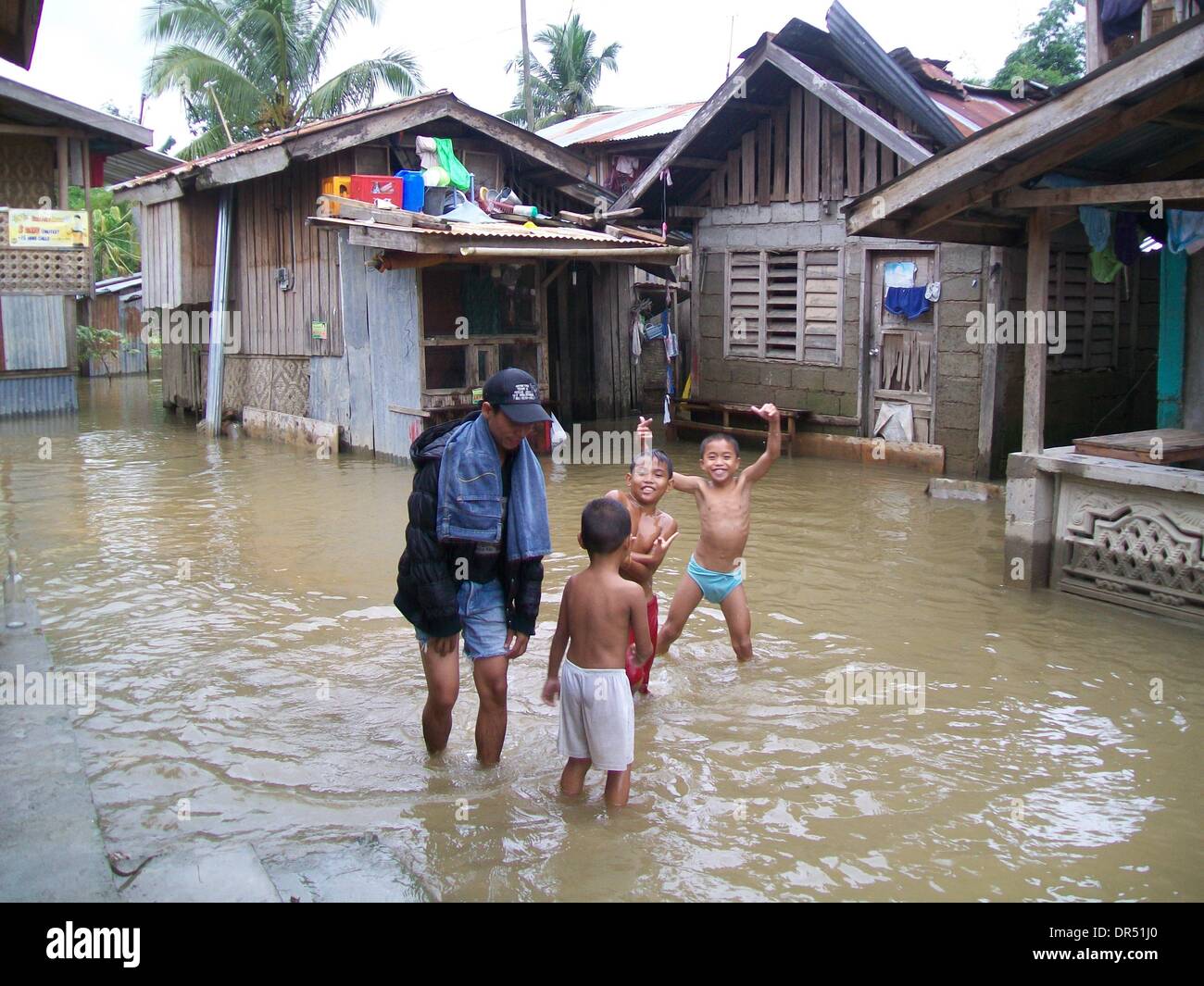 Manila. 20 ene, 2014. Los residentes vadear una comunidad inundada en Compostela, ciudad en el sur de Filipinas" del valle de Compostela, 20 de enero de 2014. La Depresión Tropical Agaton, que causaron el sur y el centro de Filipinas, ha matado a 40 personas, la Dirección Nacional de Gestión y Reducción del Riesgo de Desastres (NDRRMC Consejo) divulgado el domingo. Crédito: FLIM/Xinhua/Alamy Live News Foto de stock