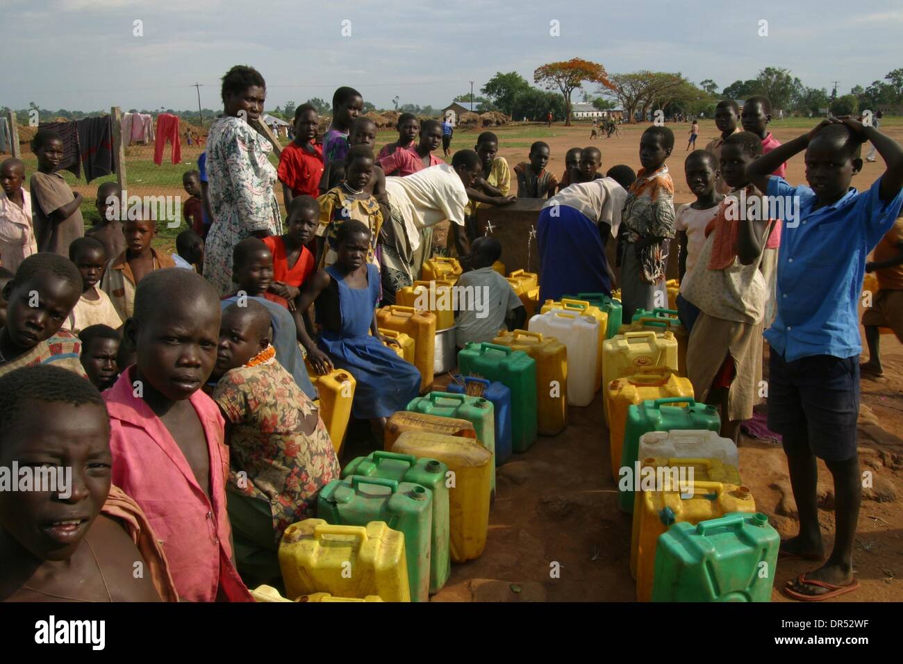 Los refugiados a acarrear agua durante su estancia en un campamento de refugiados en Uganda Foto de stock