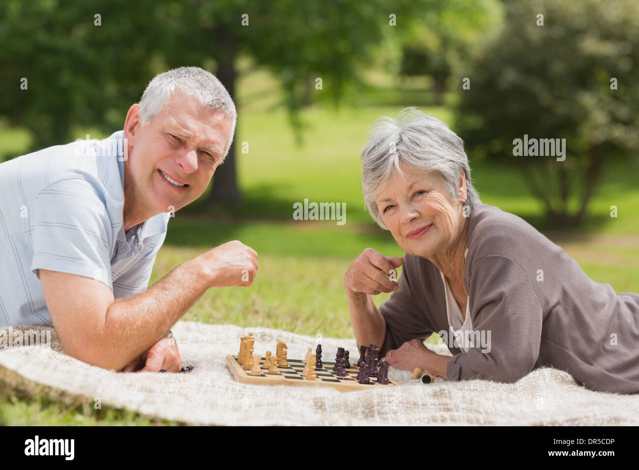 Feliz pareja senior jugando ajedrez en park Foto de stock