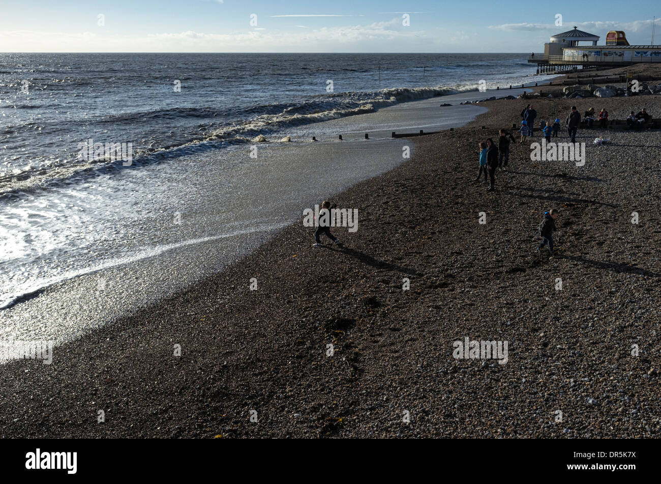 Los niños tiran piedras en el mar, Worthing. Foto por Julie Edwards Foto de stock