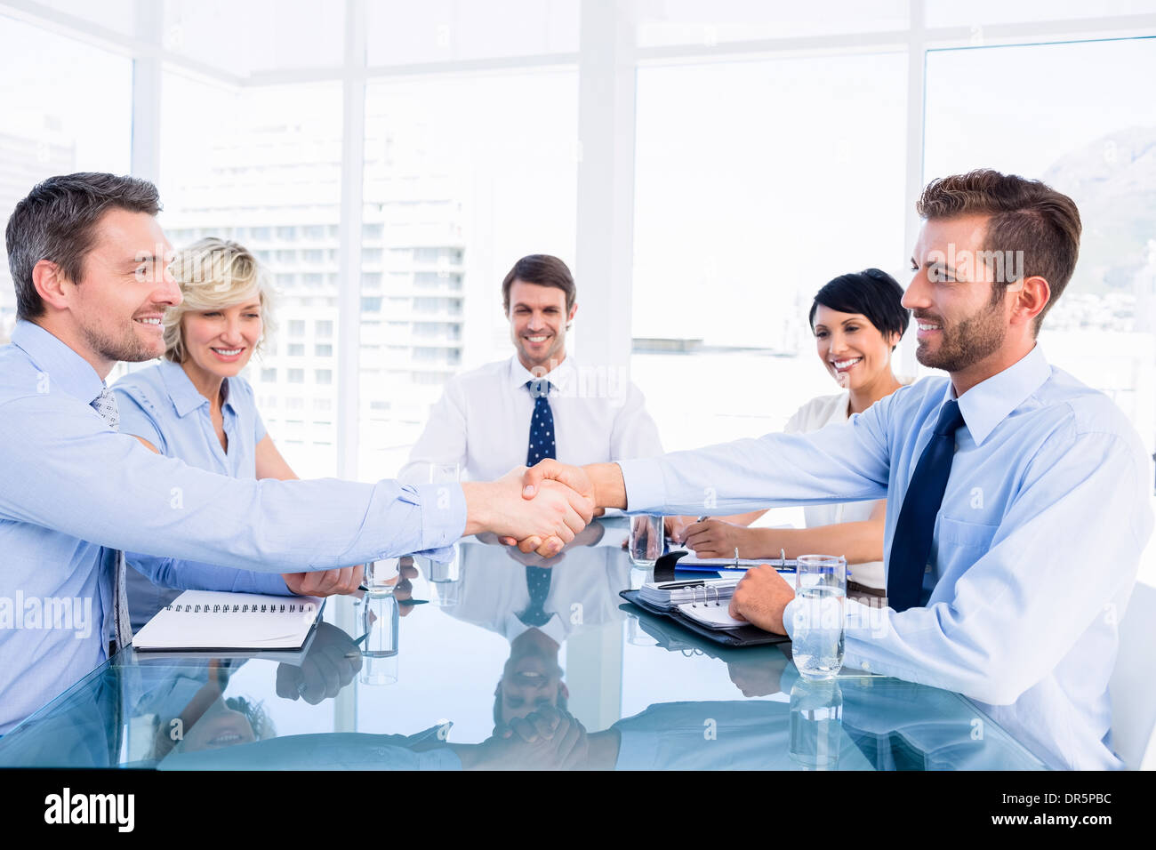 Los ejecutivos se estrechan las manos durante la reunión de negocios Foto de stock