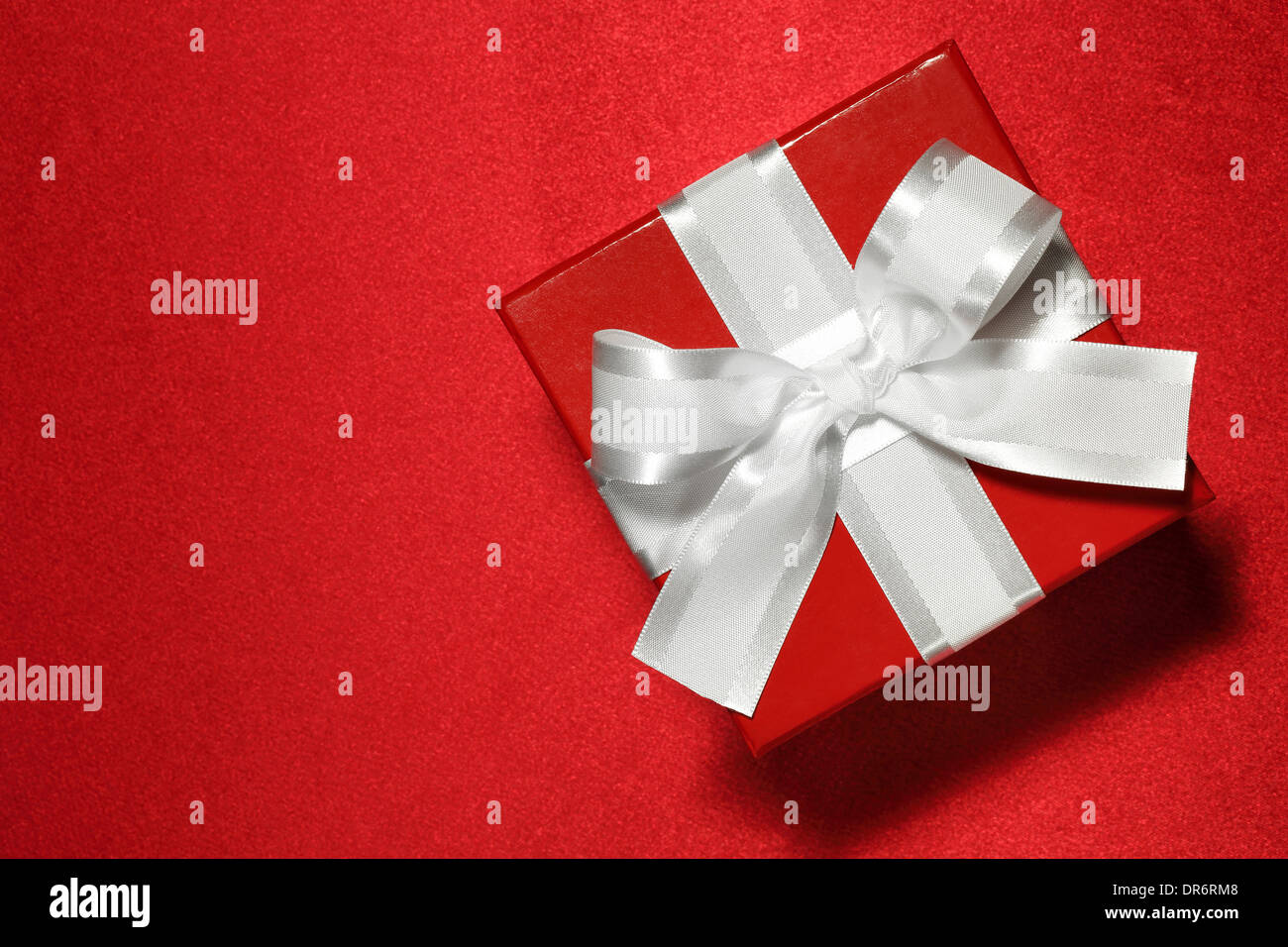 Caja de regalo sobre fondo rojo. Foto de stock