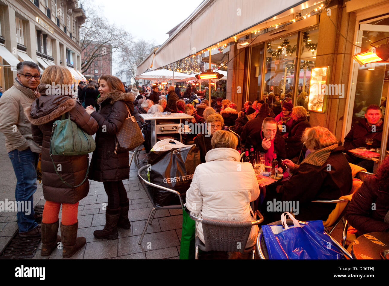 Gente sentada comiendo y bebiendo en un café de la calle, Colonia (Köln), Alemania Europa Foto de stock
