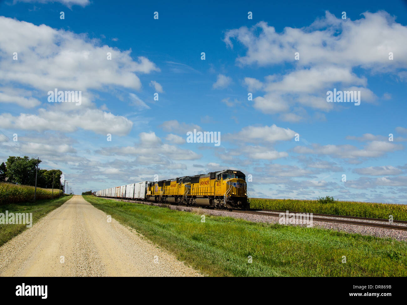 Lincoln Highway ripio junto a las vías del ferrocarril, donde el tren de Union Pacific está funcionando casi a Ashton, Illinois Foto de stock