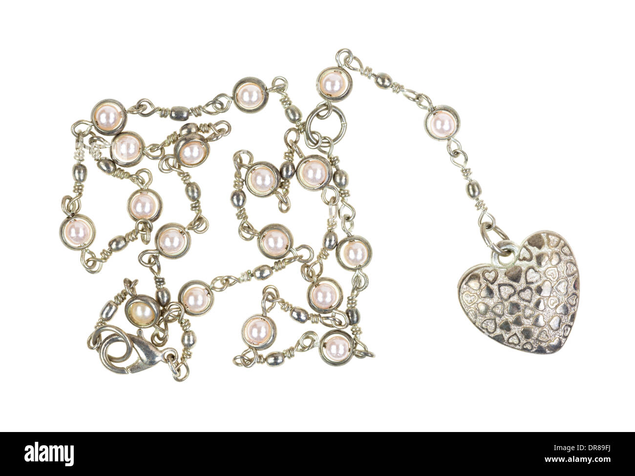 Un medallón en forma de corazón en una cadena de plata con perlas sobre un fondo blanco. Foto de stock
