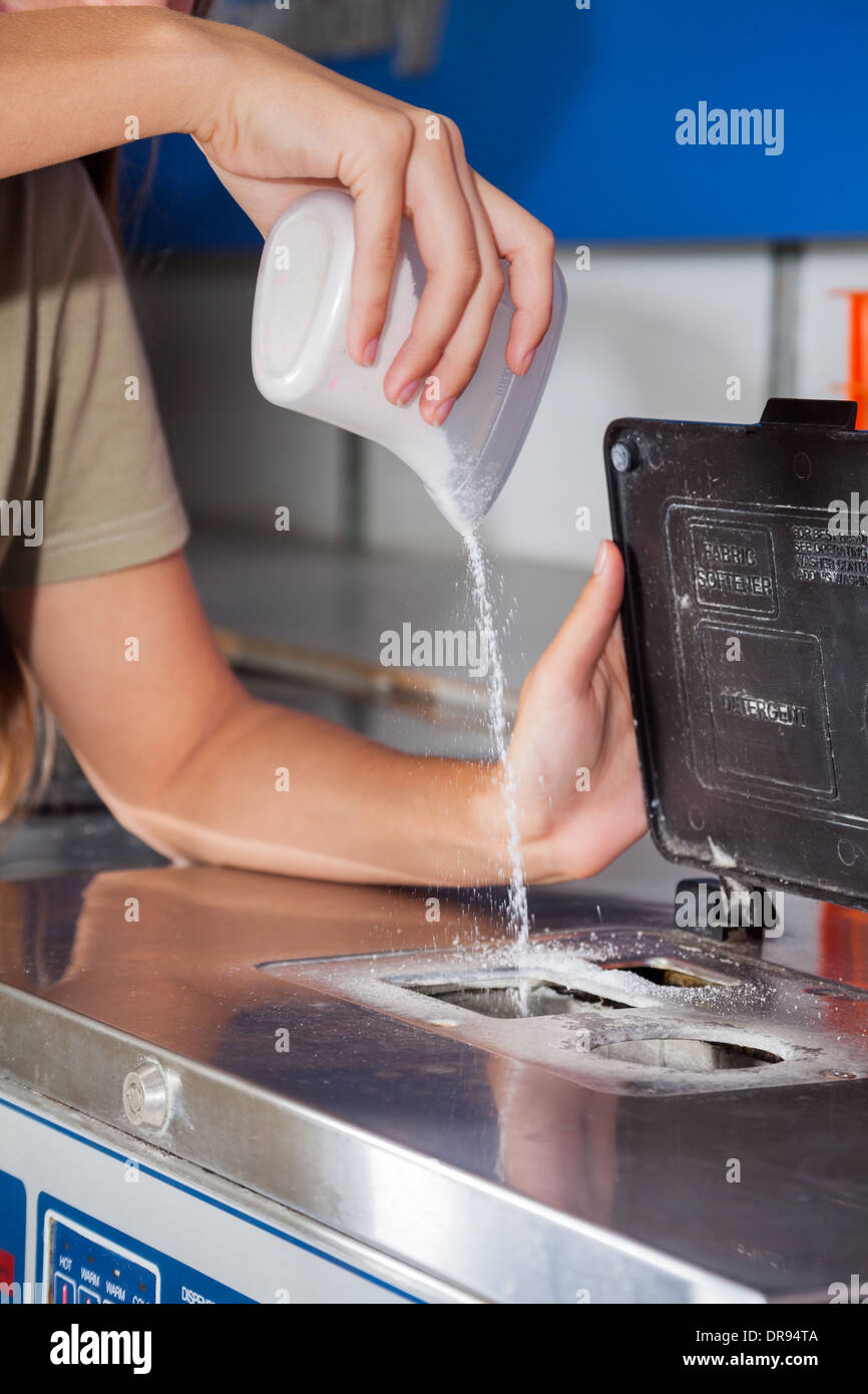 Mujer verter detergente en polvo en la lavadora Fotografía de stock - Alamy