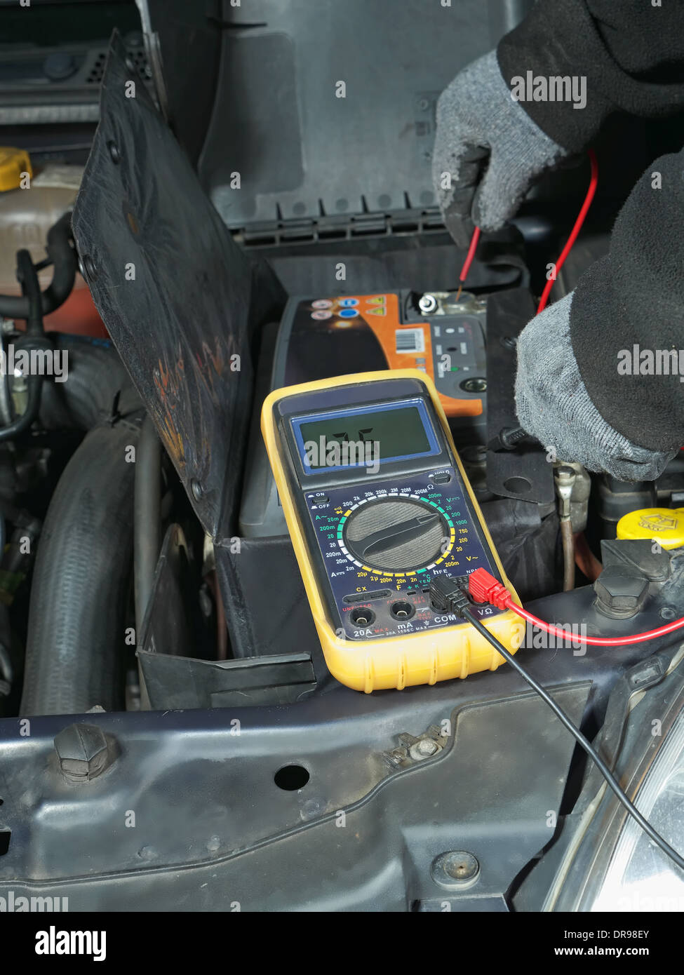 Medición de mecánica automotriz coche usando el multímetro la tensión de la batería Foto de stock
