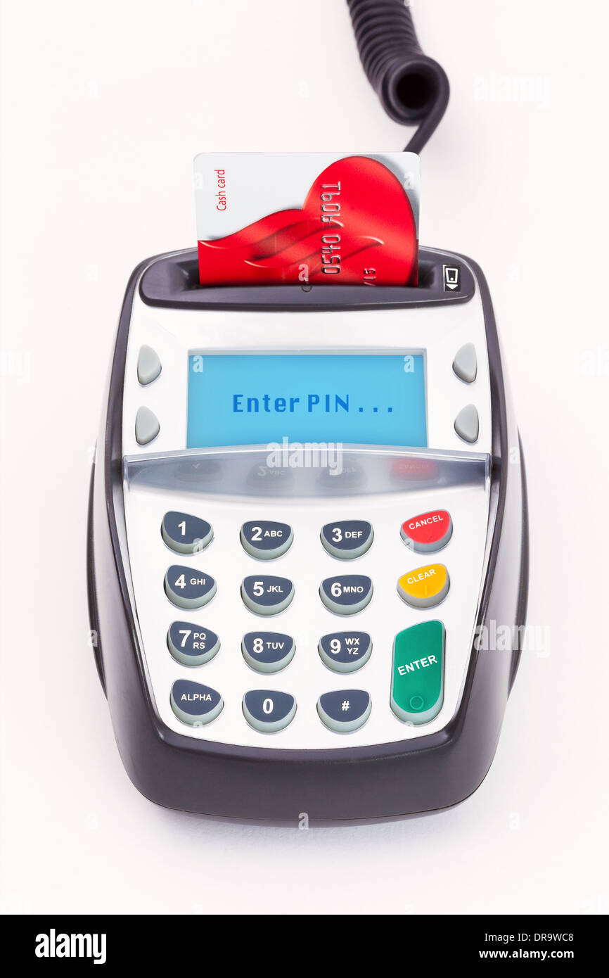 Tarjeta Bancaria con chip y PIN en una máquina sobre un fondo liso con 'Enter PIN' en la pantalla de mensaje. Foto de stock