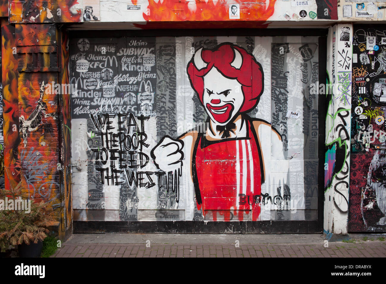 Diablo feliz y sonriente, la avaricia y la explotación concepto graffiti en Amsterdam, Holanda, Países Bajos. Foto de stock
