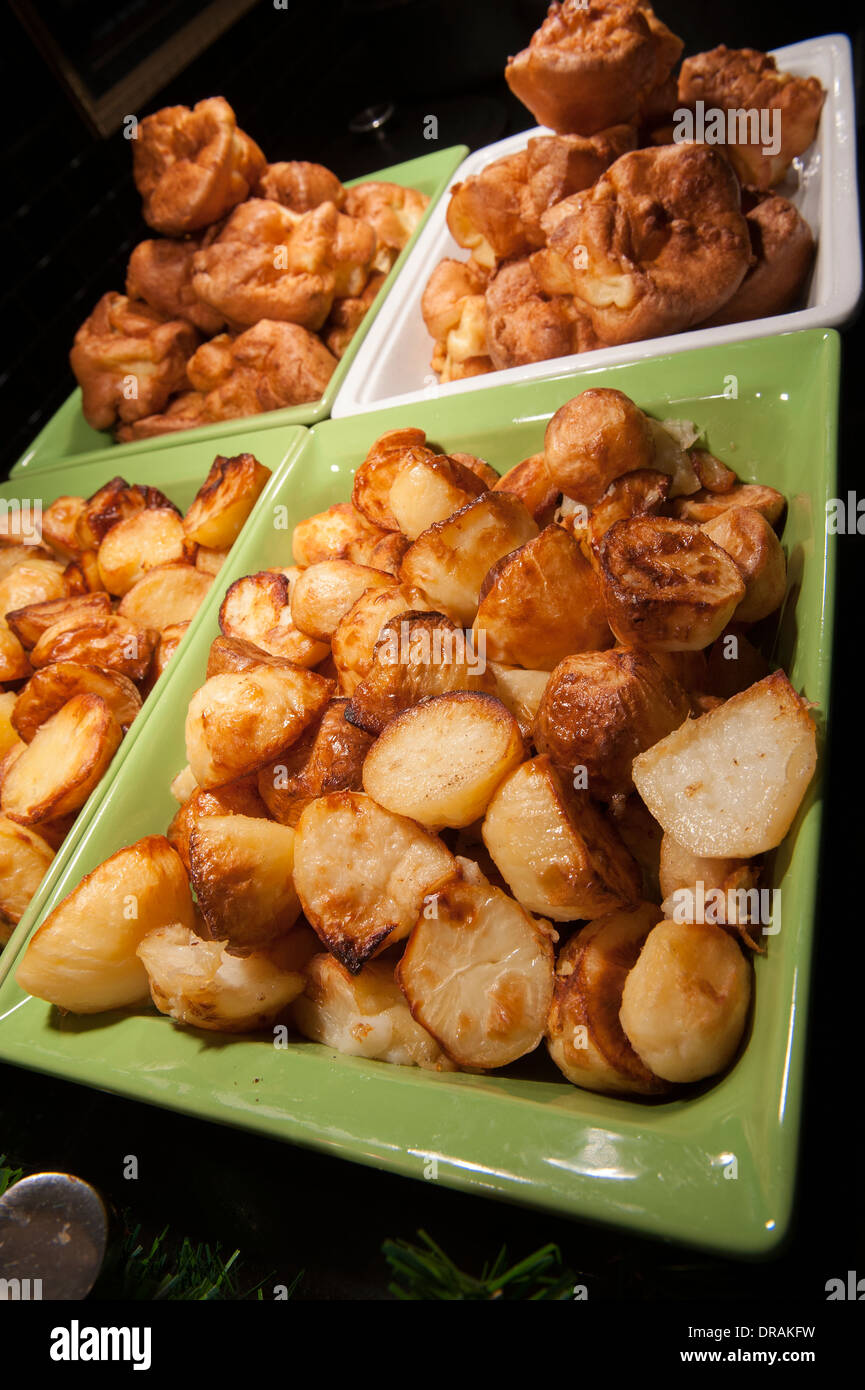 Patatas asadas y pudines Yorkshire en una parrilla libre configuración Foto de stock