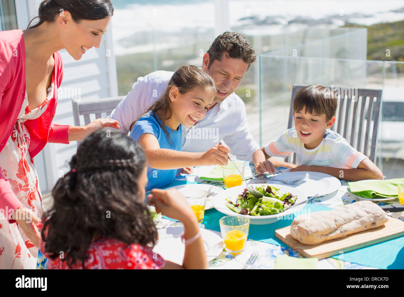 Familia comiendo en una mesa en el patio soleado Fotografía de stock - Alamy