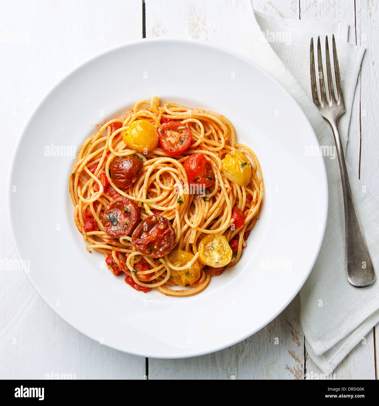 Espaguetis con salsa de tomate sobre fondo blanco de madera Foto de stock