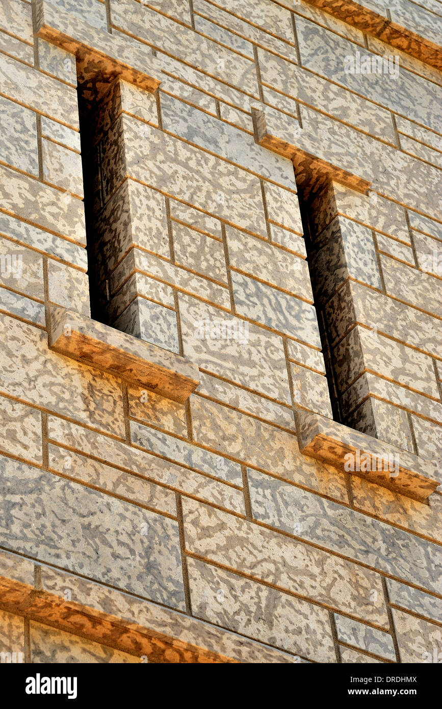 Una sección de la pared de la torre de piedra, con estrechas ranuras de ventana Foto de stock