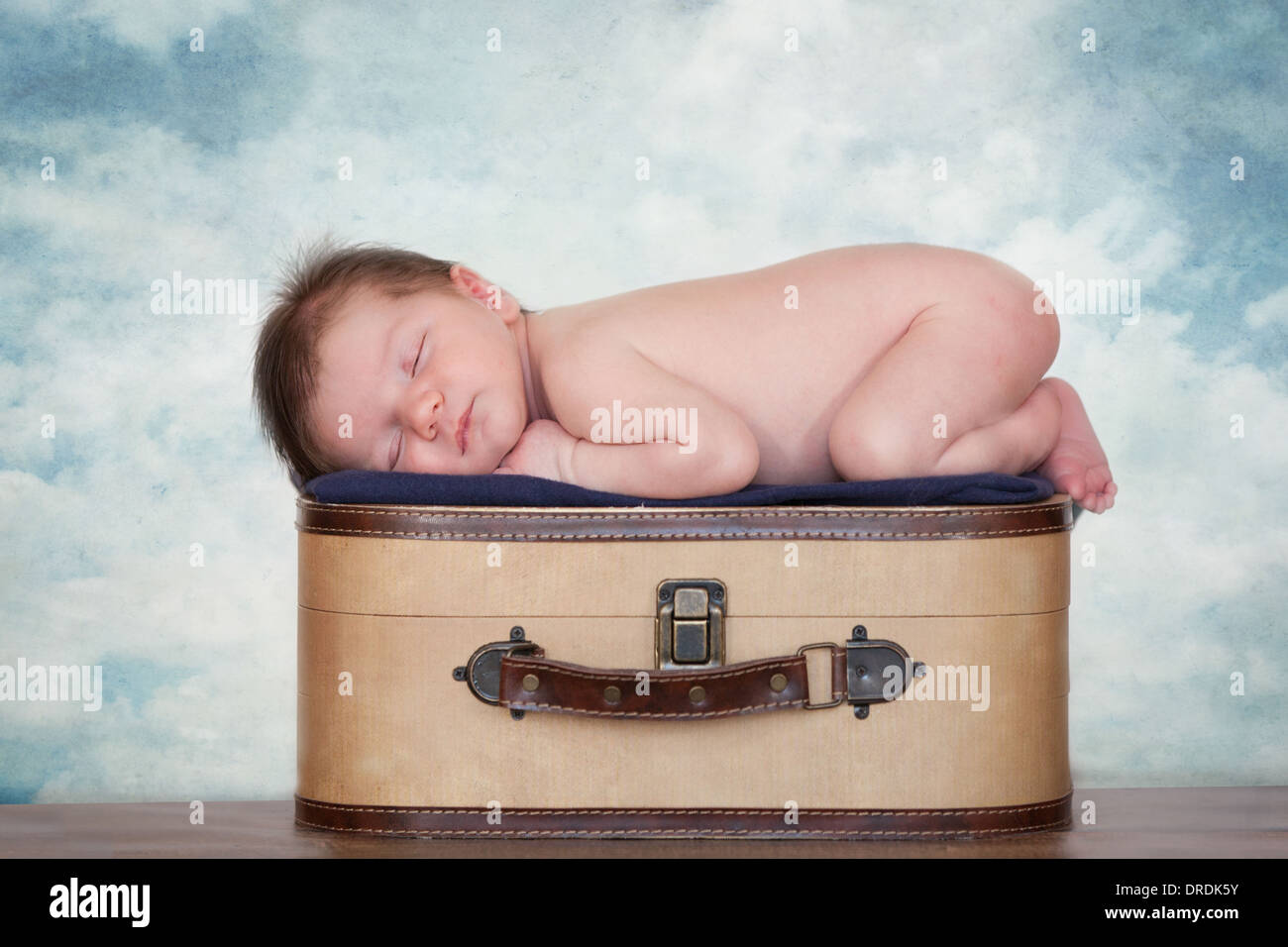 Bebé recién nacido niño durmiendo profundamente en una maleta con un telón  de fondo nublado Fotografía de stock - Alamy