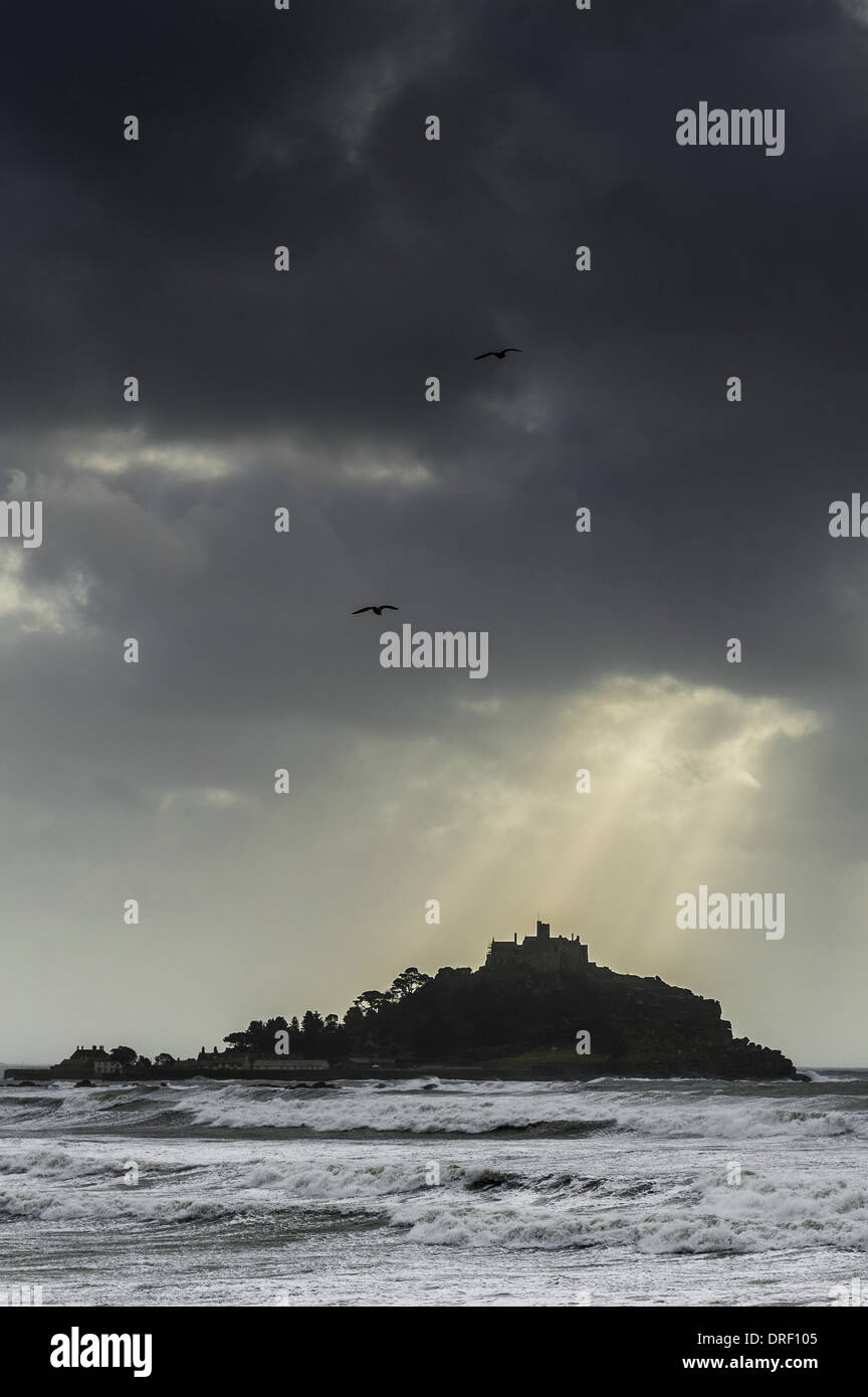 La luz del sol rompiendo nubes de tormenta sobre St Michaels Mount en Cornwall. Foto de stock