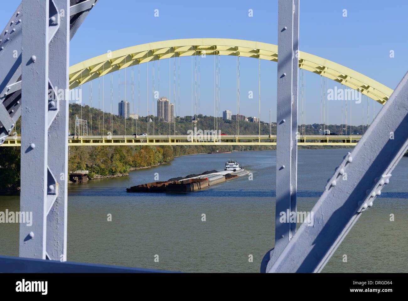 Una barcaza cargada con materiales de reciclaje y carbón pasa los puentes sobre el Río Ohio entre Cincinnati, Ohio y Covington, KY. Foto de stock