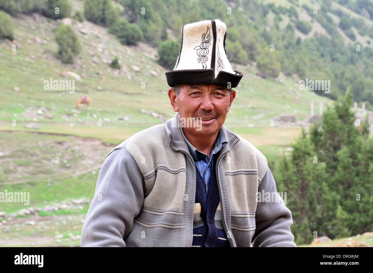 Hombre kirguise vistiendo un sombrero tradicional de Kirguistán en las montañas del sur de Kirguistán Foto de stock