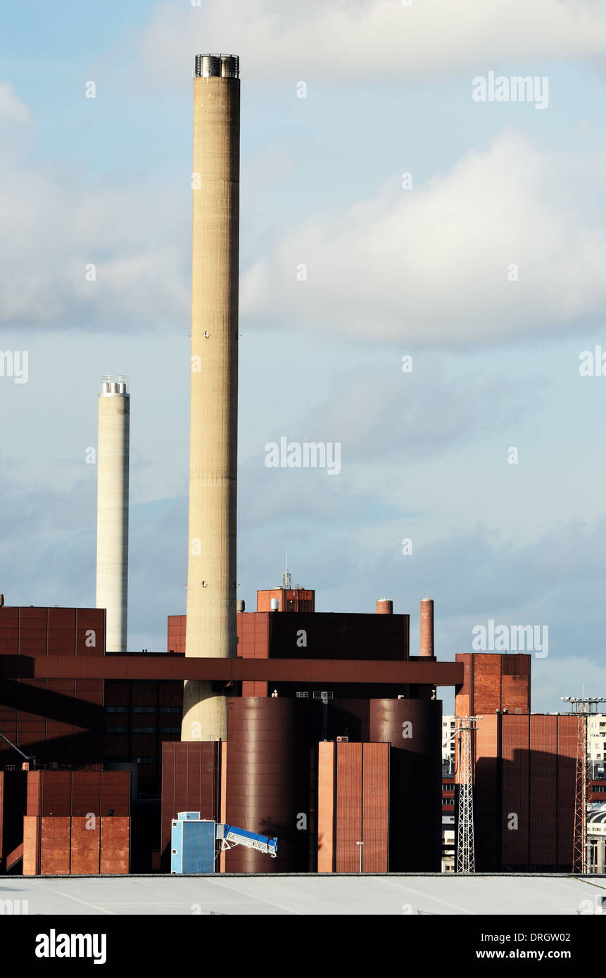 Edificio industrial y chimenea contra el cielo gris Foto de stock
