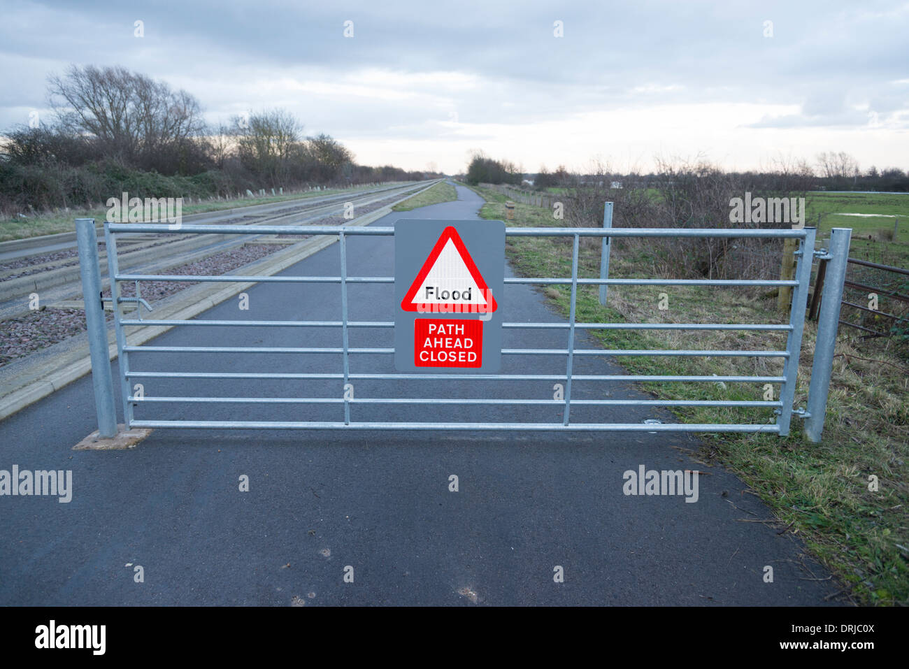 Un sendero de la puerta con el cartel de cerrado debido a las inundaciones en el camino que discurre paralelo a la vía del bus guiado en Cambridgeshire REINO UNIDO Foto de stock