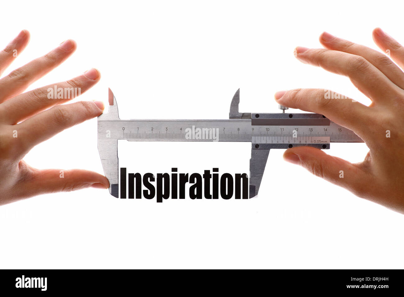 Dos manos sosteniendo un calibre, medir la palabra "inspiración". Foto de stock