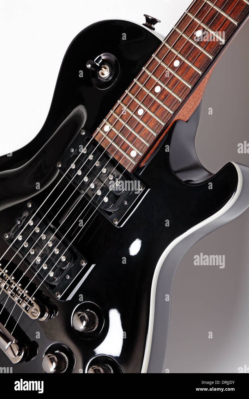 Elegante diseño en color negro cerca de guitarra eléctrica sobre un fondo  gris, Foto de estudio Fotografía de stock - Alamy