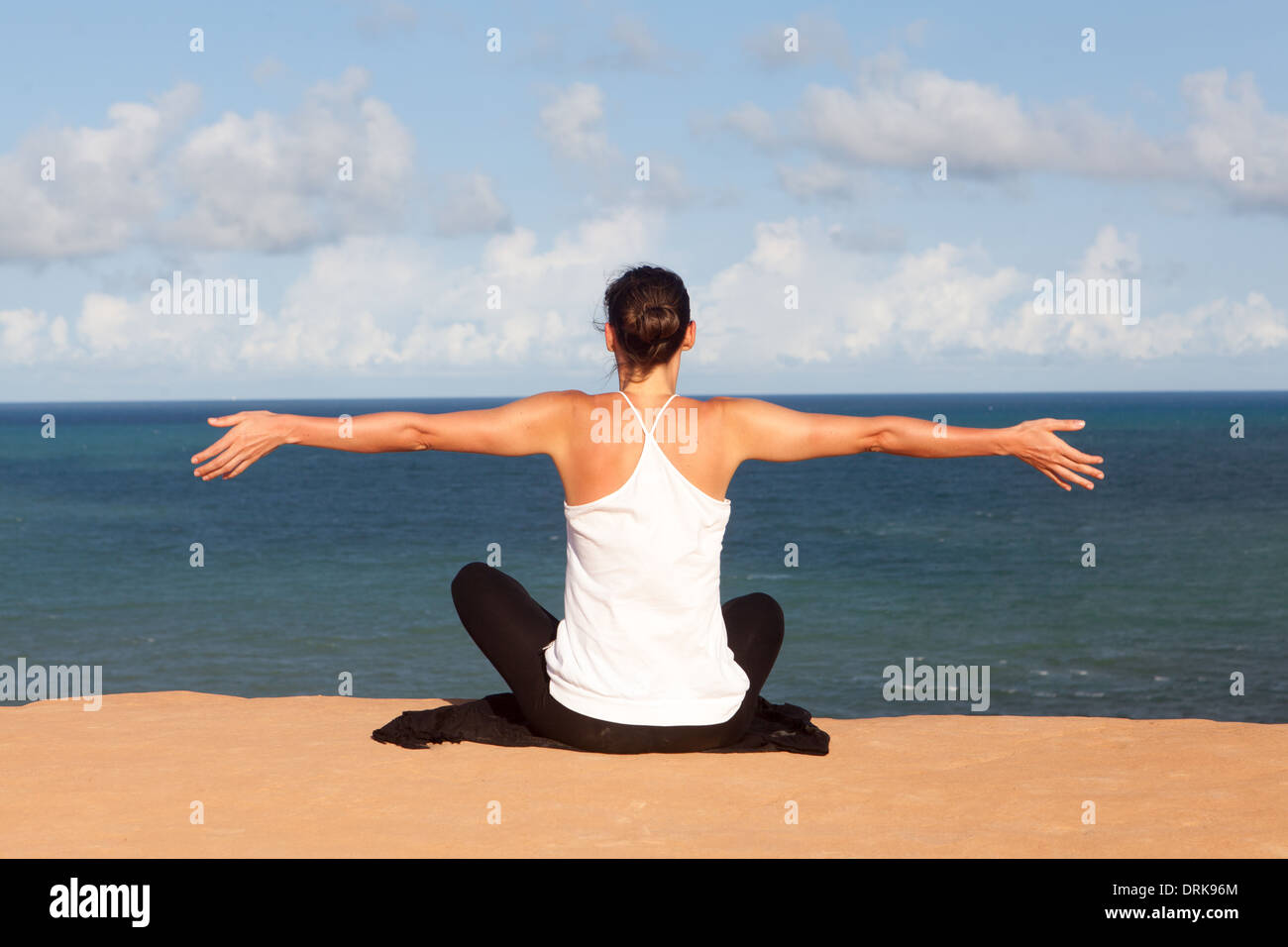 Mujer haciendo ejercicio de yoga en la playa Foto de stock