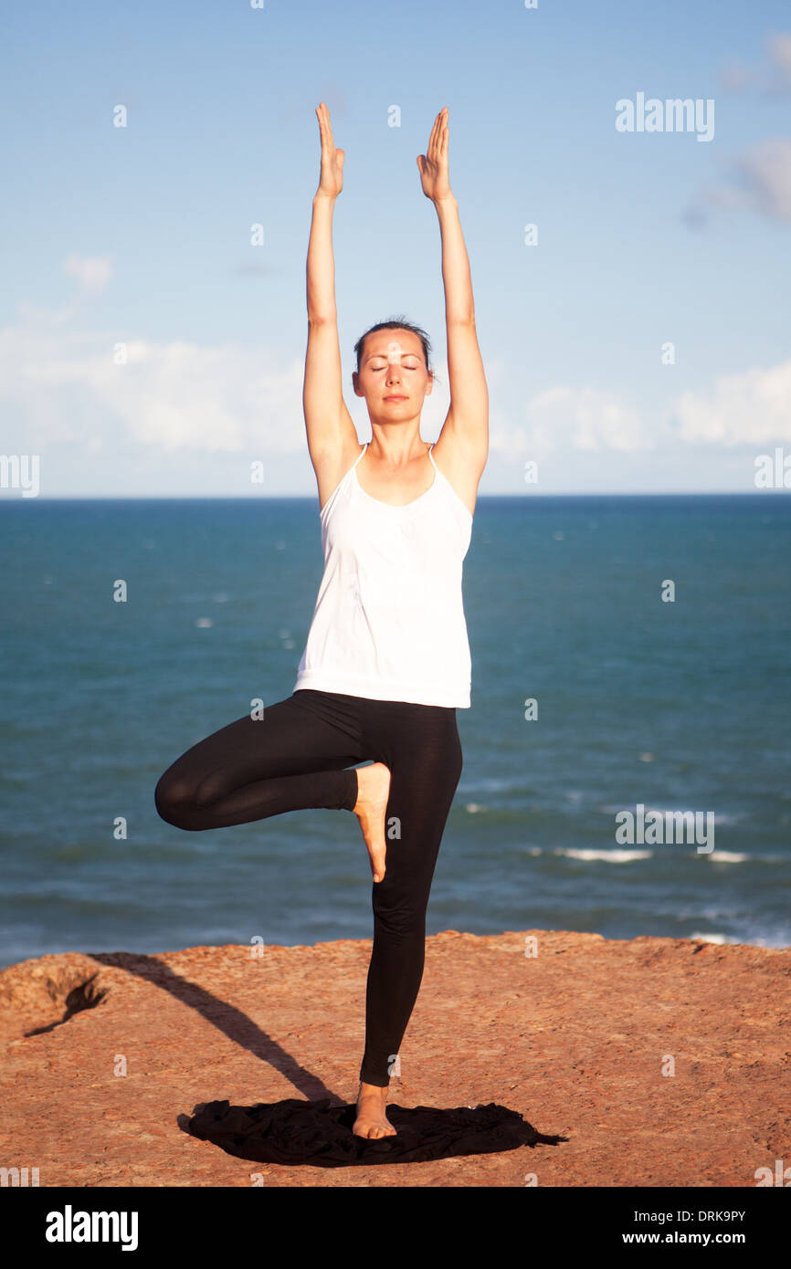 Ejercicio de Yoga en la costa del mar - el árbol Foto de stock