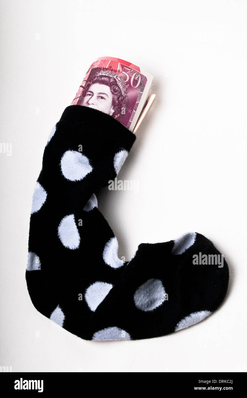Billetes de cincuenta libras rellenas en un calcetín Foto de stock
