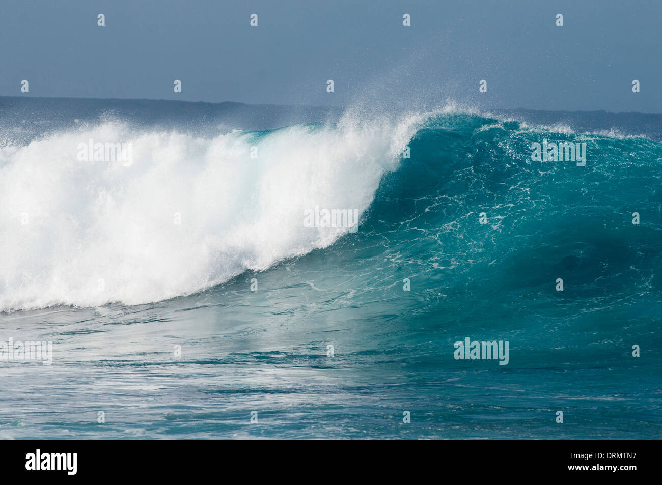 Onda de energía de ondas de agua de mar embravecido mar rompiendo breakers surf spray azul caballos blancos de sal Foto de stock