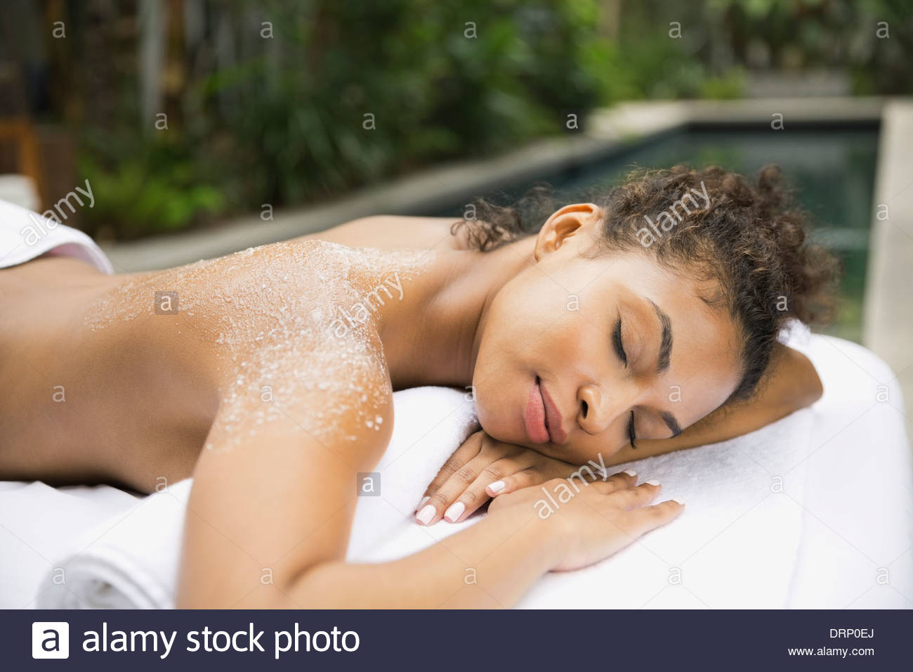 Mujer relajada en el spa de día recibiendo body scrub Foto de stock
