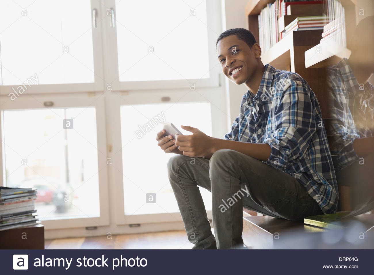 Sonriente adolescente con tableta digital en casa Foto de stock