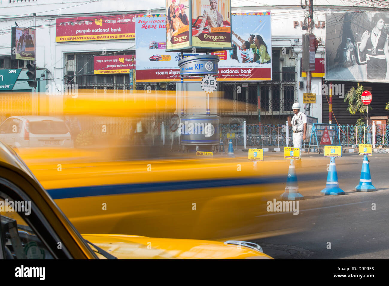 Los taxis de color amarillo y un hombre de la policía de tráfico en Calcuta, India. Foto de stock