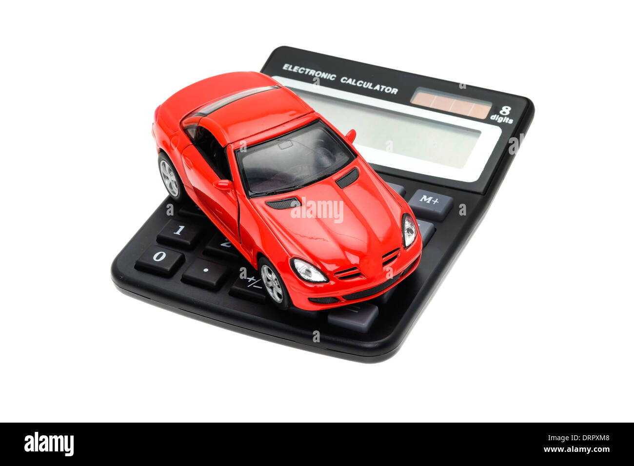 Un coche deportivo rojo colocado en una calculadora - Foto de estudio con un fondo blanco y una profundidad de campo limitada Foto de stock