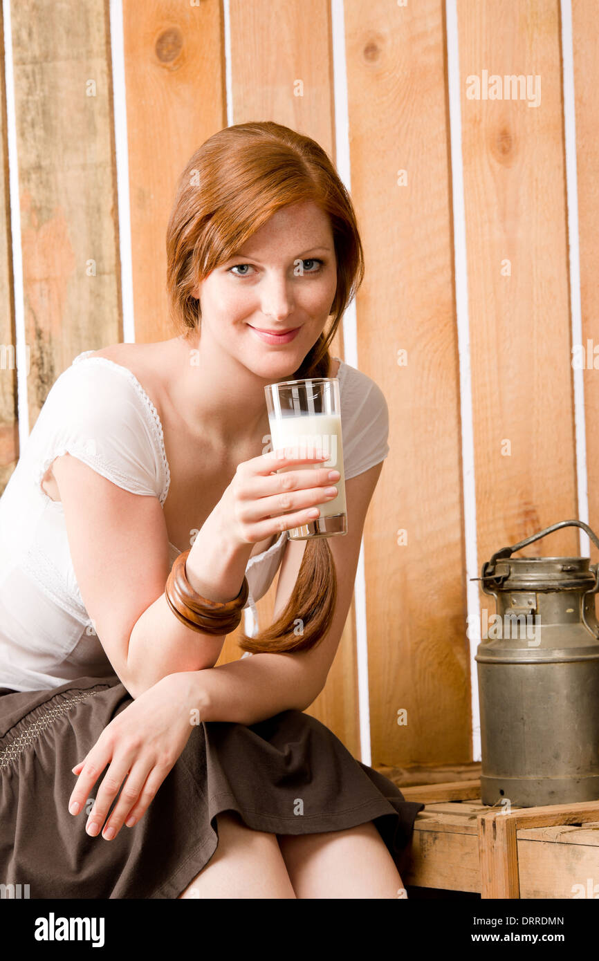 Mujer joven beber leche natural en establo Foto de stock