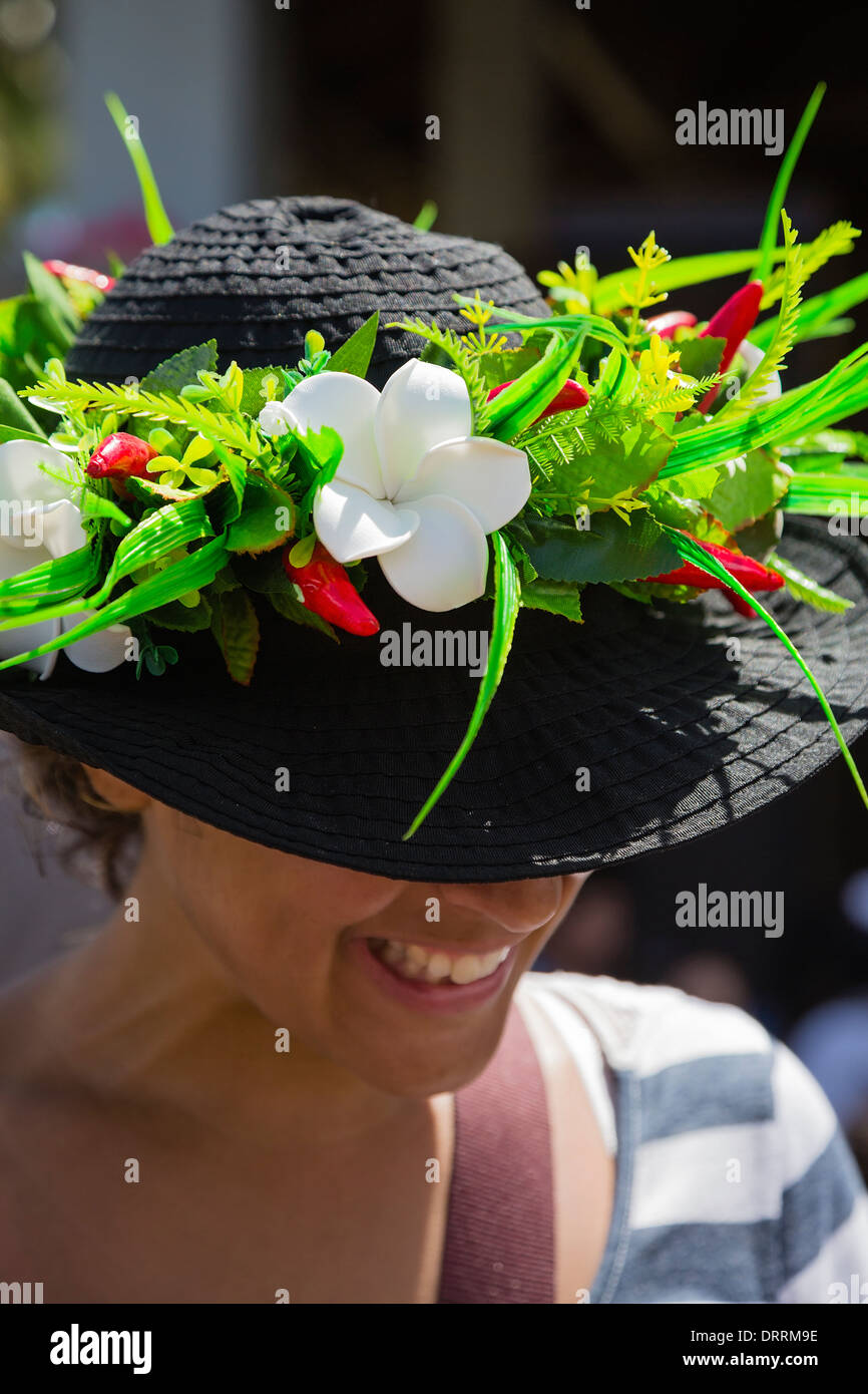 Una mujer vistiendo un sombrero negro adornado con flores tropicales. Rarotonga en las Islas Cook. Pacífico Sur. Foto de stock