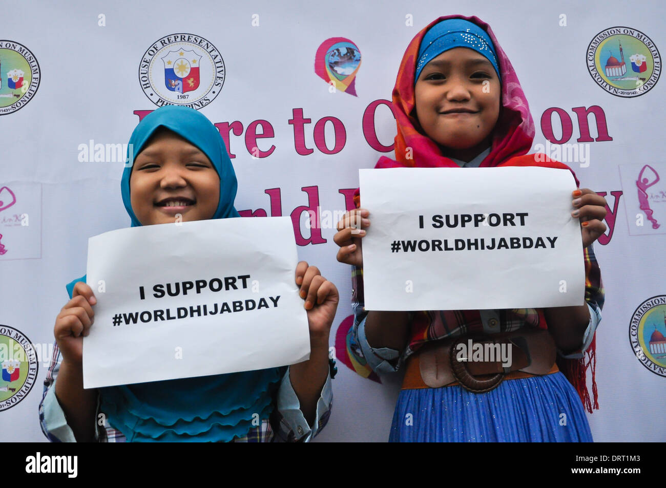 Dos chicas musulmanas, posando para la cámara, mostrar cartel apoyando el Hijab Día Mundial de la ciudad de Quezon. Foto de stock
